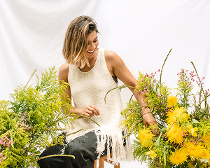 Floral designer arranging yellow and green flowers at her studio.
